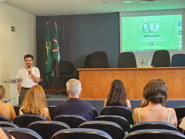 Luiz falando ao microfone no XVI Encontro sobre Qualificação em Psicologia Hospitalar